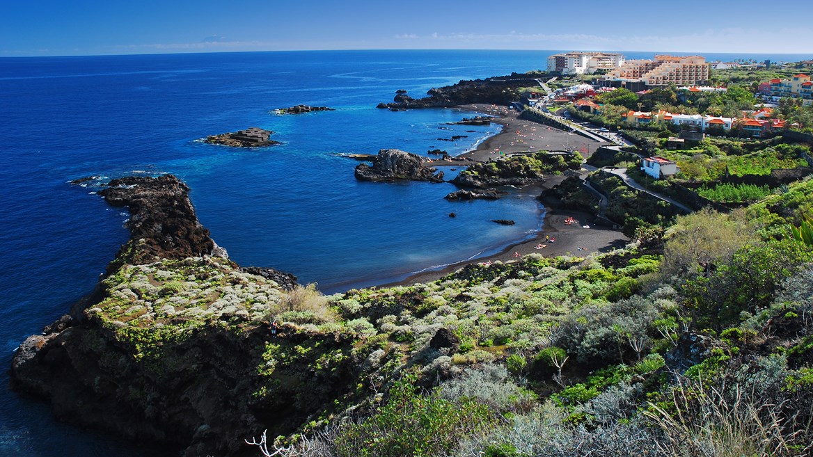 La playa de Los Cancajos, en La Playa de Los Cancajos in La Palma is made up of several small volcanic sand coves and is perfect for cave diving and snorkelling., está formada por varias calitas de arena volcánica y es perfecta para practicar buceo de caverna y snorkel.