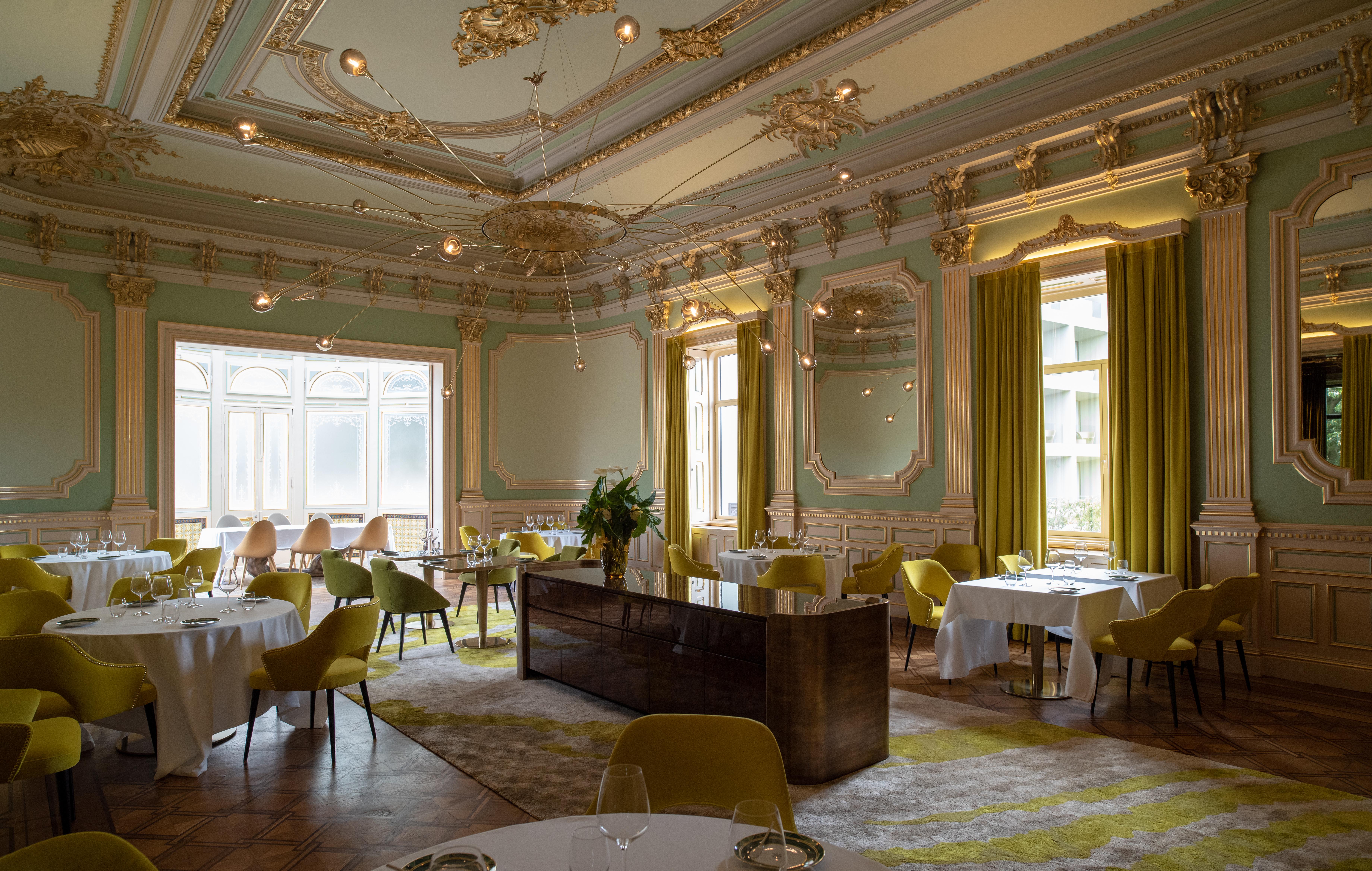 The main dining room of the restaurant mixes a historicist style with modern touches in a colour palette of yellows and greens