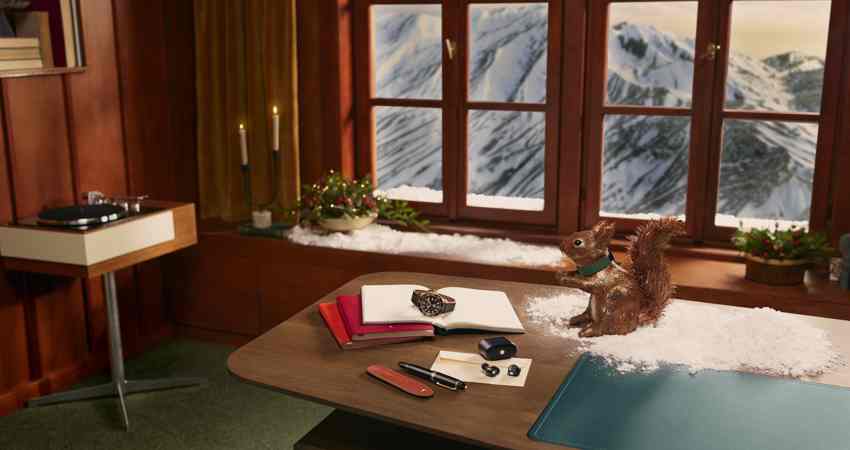 Get up to 10 Avios for every €1 you spend with Montblanc. Pictured here, from the brand's Christmas campaign, is a wood-panelled office with a view of a snow-capped mountain.