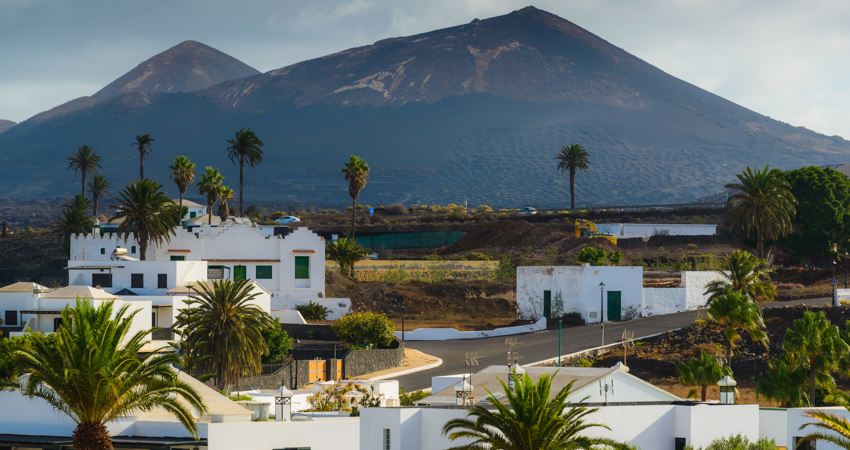 In the foreground is the village of Yaiza, with its low whitewashed houses, framed by the profile of one of the island's volcanoes.