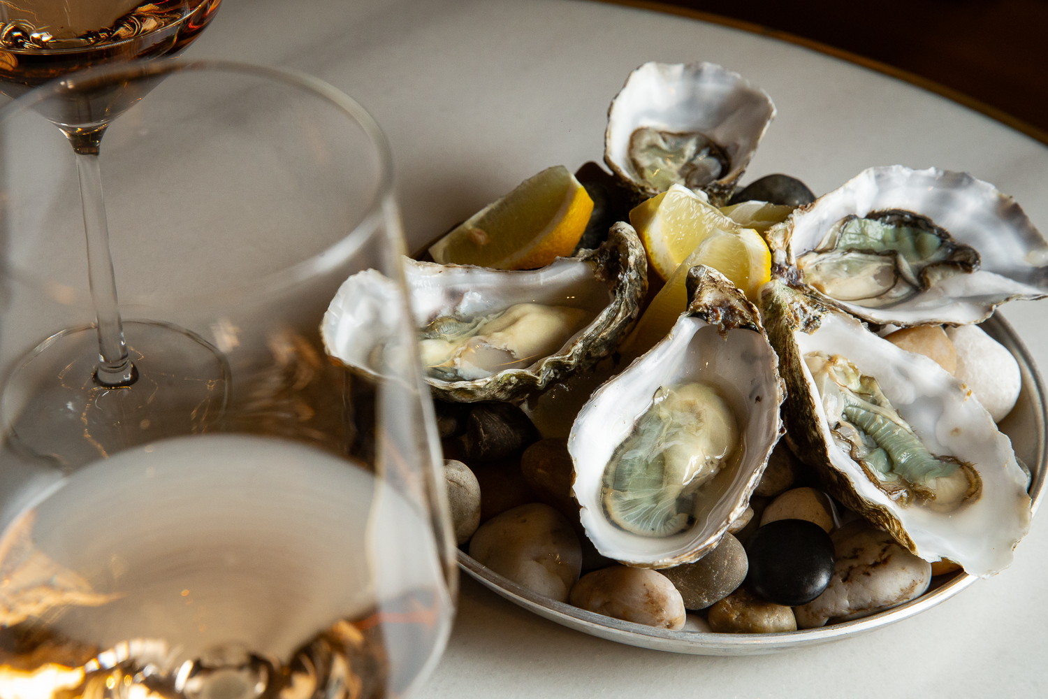 Plato de ostras verdes de Huitres Poget, acompañado de increíbles copas de vino blanco, una especialidad de Barra Alta