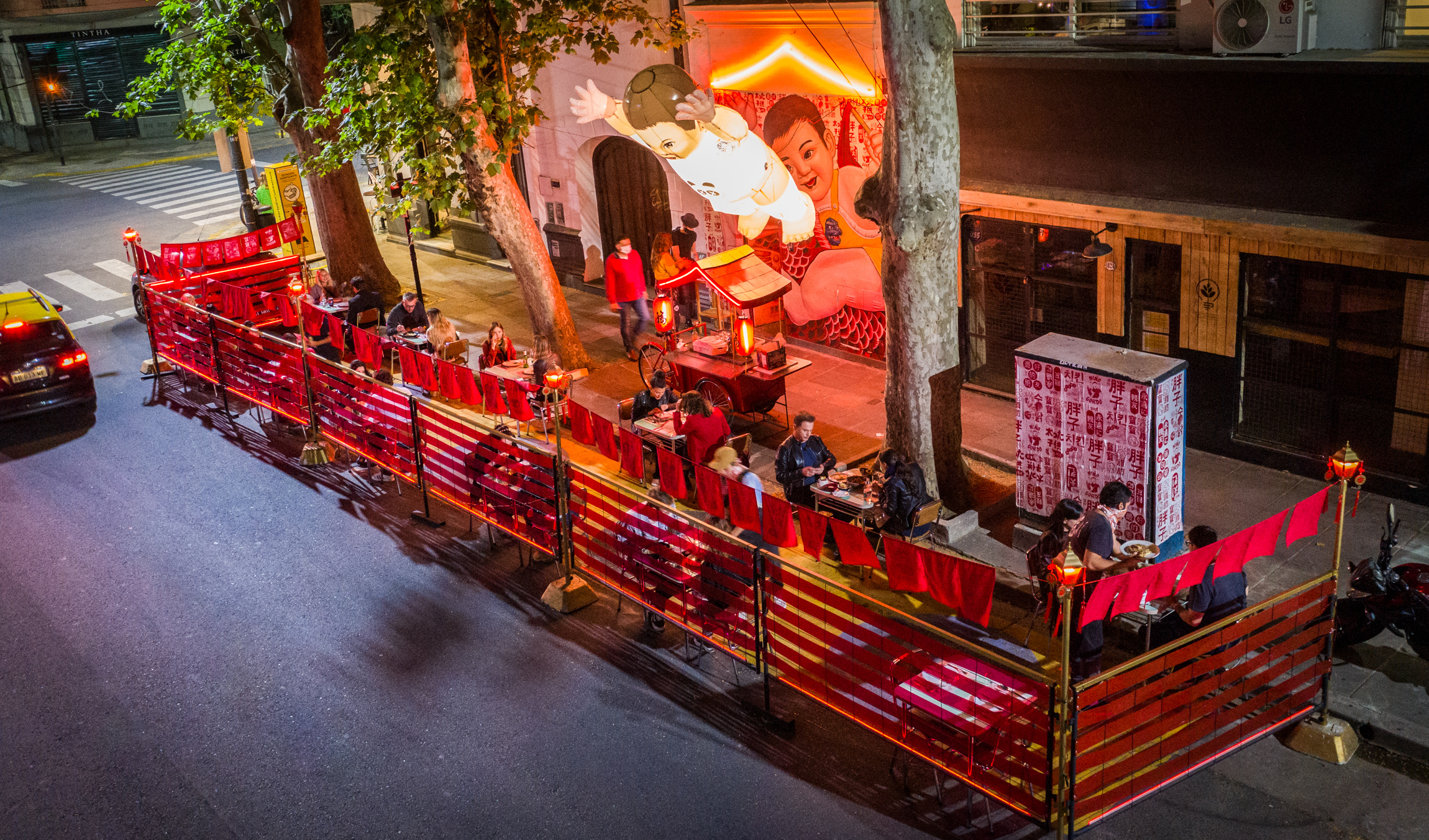 El comedor exterior del Niño Gordo, con su característico mobiliario rojo y sus brillantes lámparas en forma de adorable niño pequeño