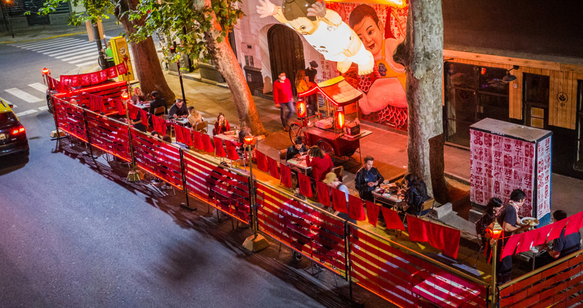 El comedor exterior del Niño Gordo, con su característico mobiliario rojo y sus brillantes lámparas en forma de adorable niño pequeño