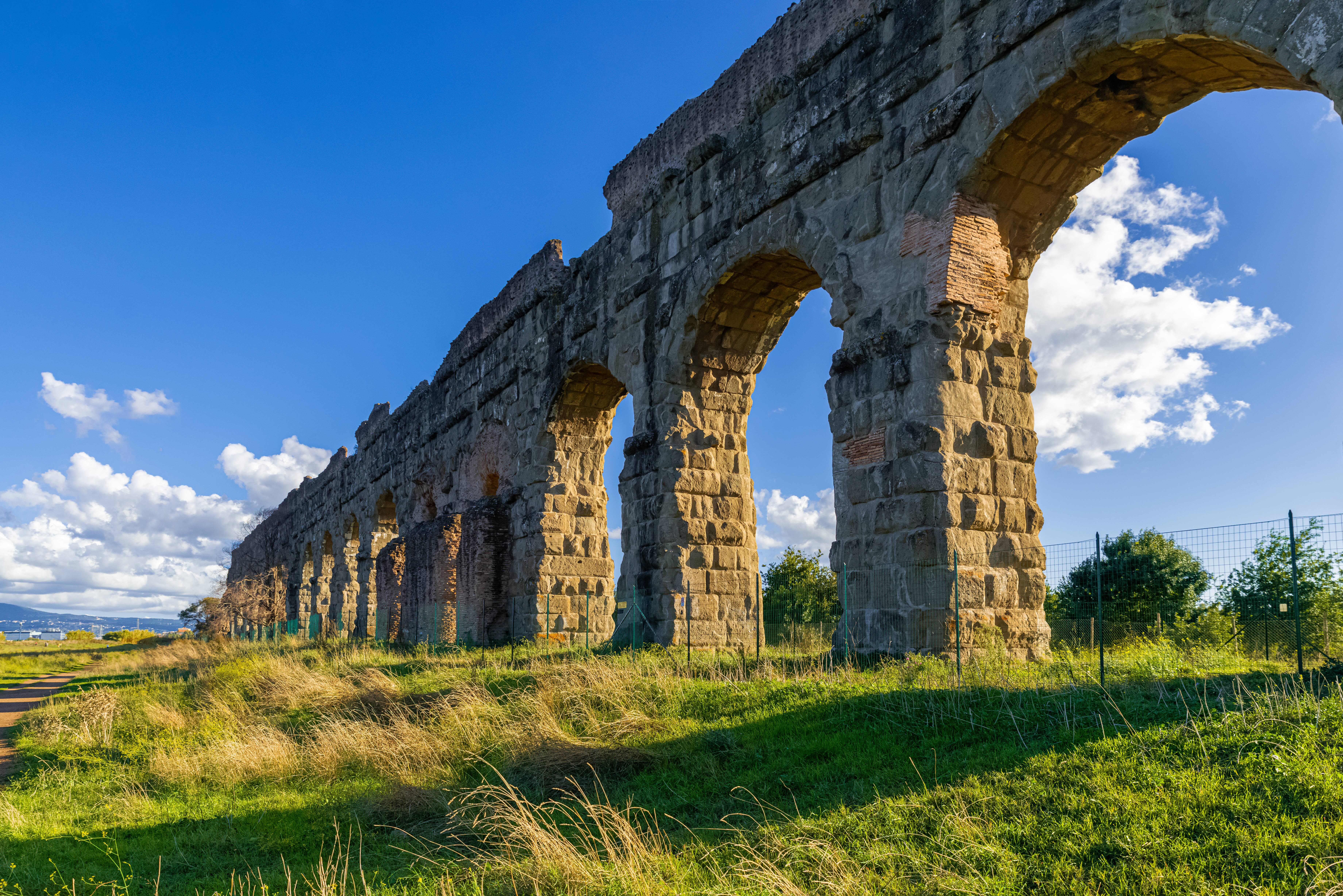 View of the Aqueduct Park at sunset, with light falling on one of the aqueducts which is lost in the horizon.
