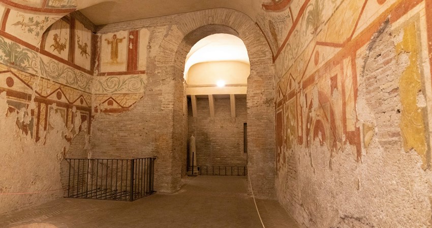 In the picture, the interior of one of the Casas del Celio, with colourful ochre-toned frescoes on the walls. 