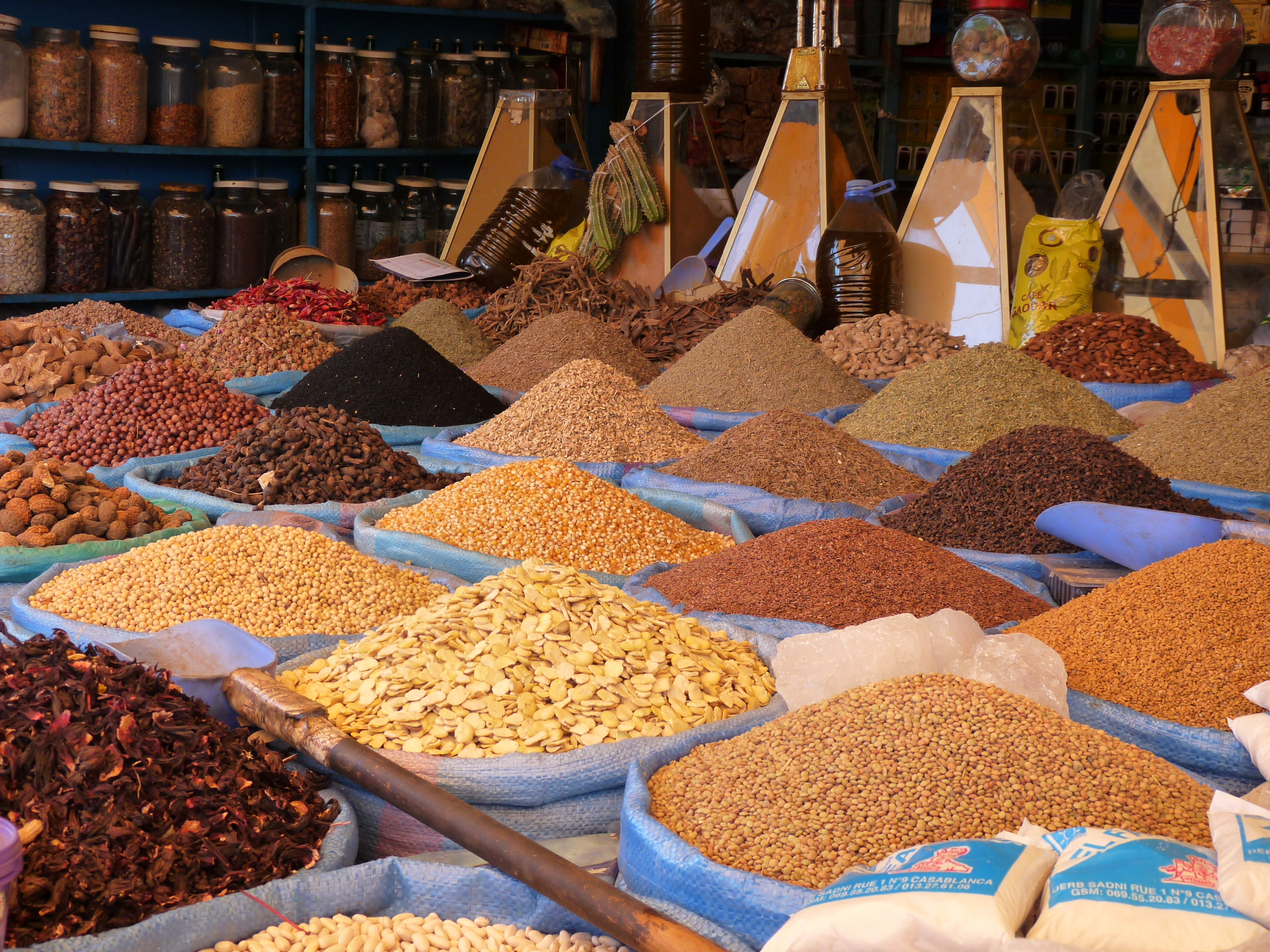 The picture shows a spice stall in the Central Market, with different types of products in piles in sky-blue containers or in glass pyramid dispensers.