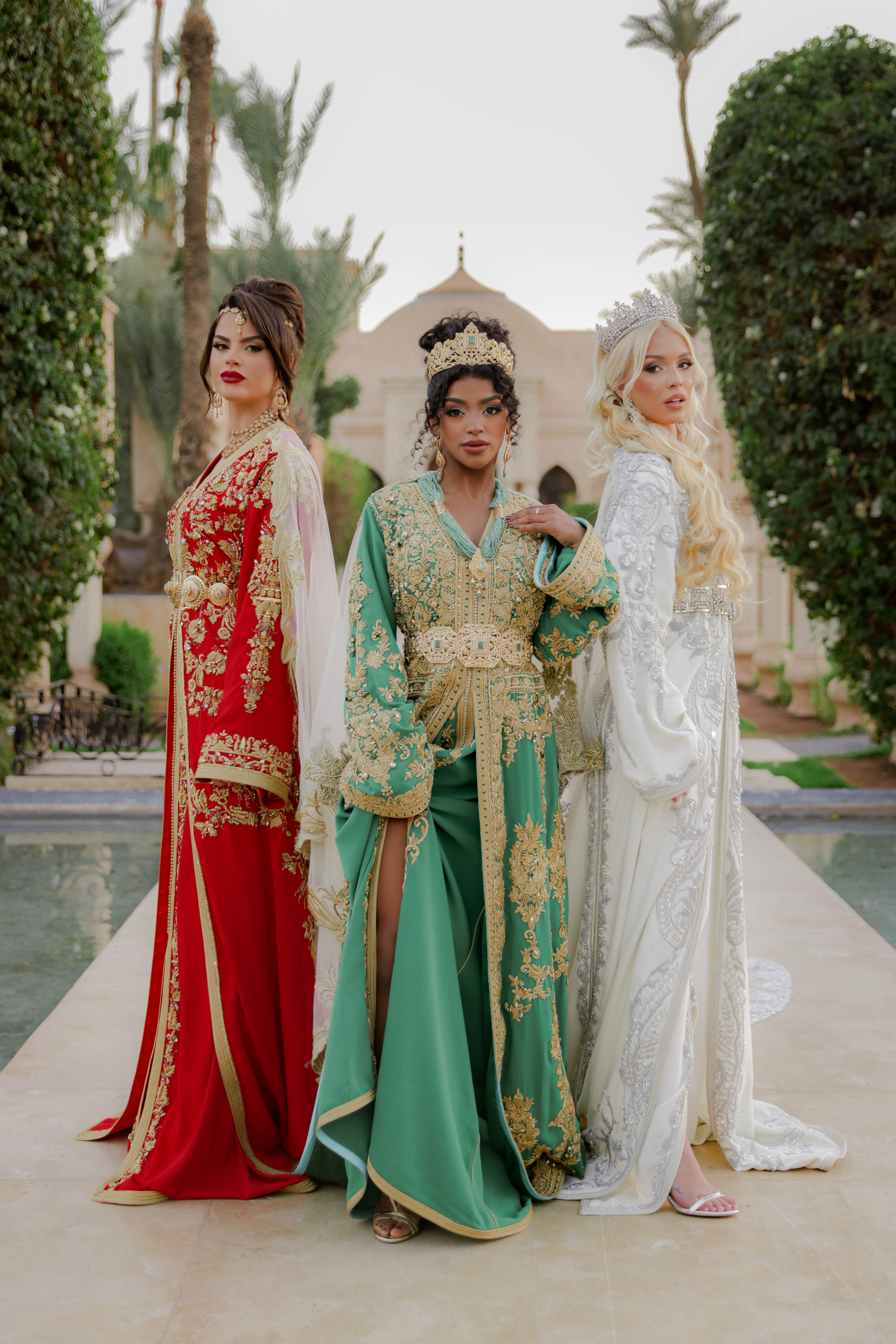 In the picture, three models pose in luxury kaftans by designer Bouchra Filali Lahlou, in red and green with gold embroidery, or in white with pleated trim