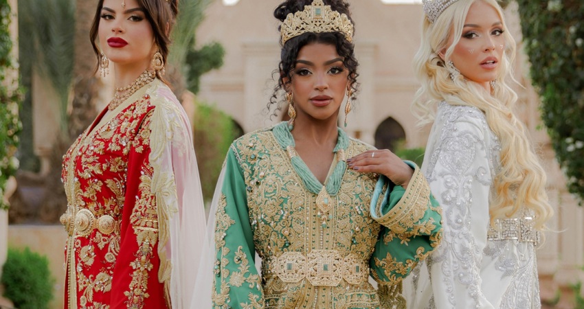 In the picture, three models pose in luxury kaftans by designer Bouchra Filali Lahlou, in red and green with gold embroidery, or in white with pleated trim