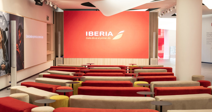 Espacio Iberia Madrid 2025. En la imagen, un pequeño auditorio con pantalla y asientos de terciopelo sin respaldo.