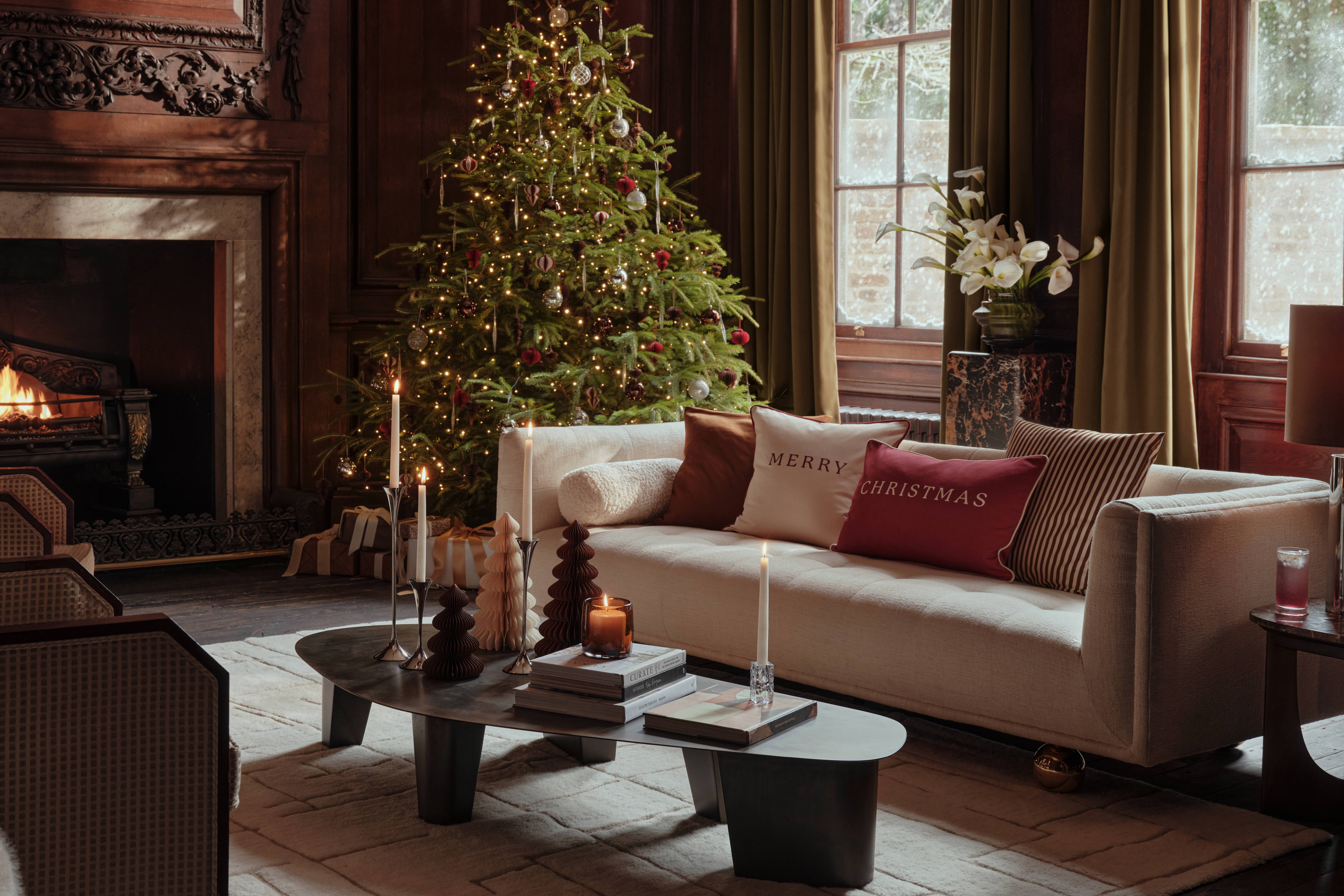 En la imagen, un salón con un árbol de Navidad y decoración de H&M Home