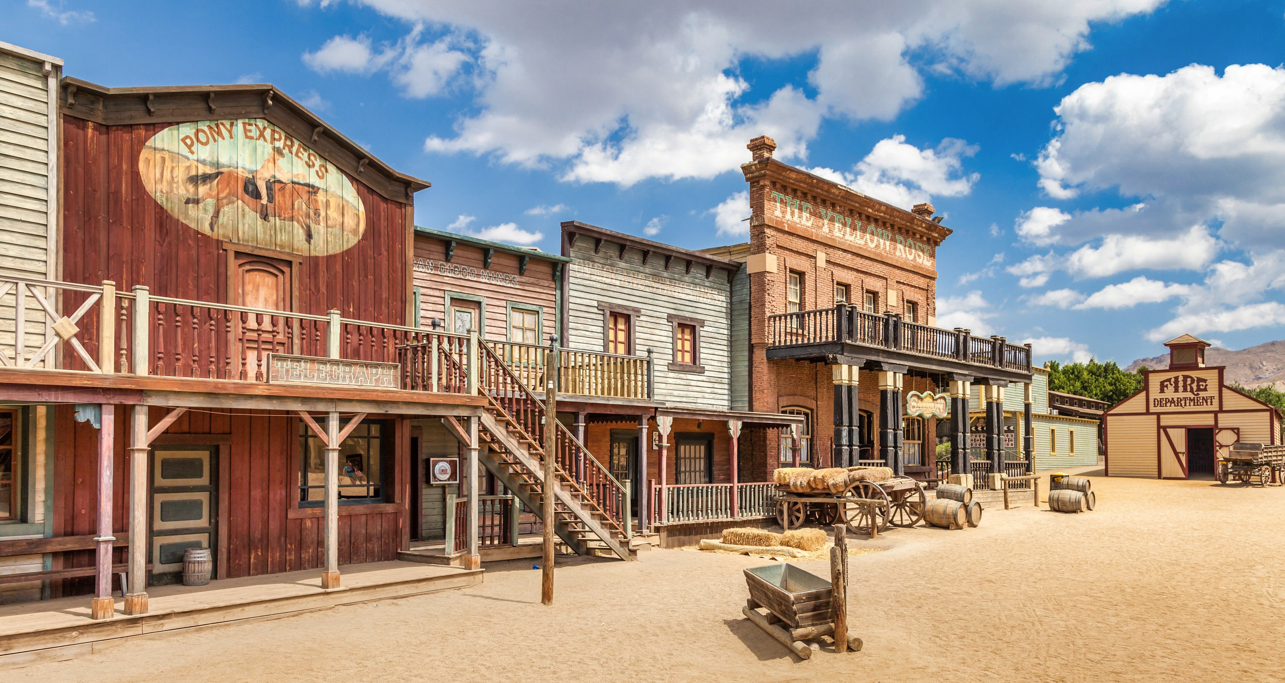The image shows a Wild West setting with red wooden houses.